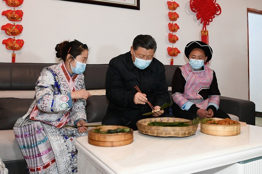 2021年2月3日下午，習(xí)近平在貴州畢節(jié)市黔西縣新仁苗族鄉(xiāng)化屋村苗族村民趙玉學(xué)家，同一家人邊聊家常邊制作當(dāng)?shù)貍鹘y(tǒng)節(jié)日食品黃粑。新華社記者 李學(xué)仁 攝